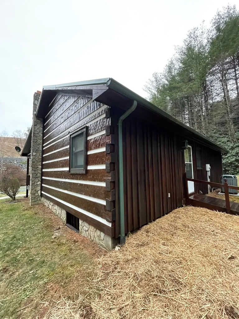 Completed exterior wood restoration on a dark-stained cabin