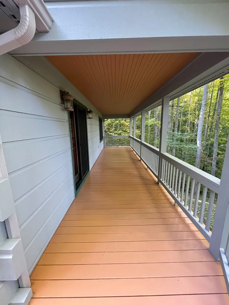 Finished covered porch with refreshed floor and white siding